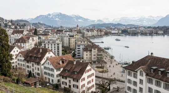 Panorama einer Schweizer Stadt mit Wohnhäusern und Bergkulisse – Immobilienpreise Schweiz